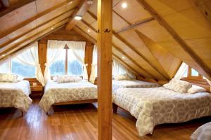 two beds in a room with a attic at Vacaciones en Cuenca, quédate en Picota Cucho una encantadora quinta VIP con jacuzzi, turco, zona BBQ a 10km del centro de la ciudad - 20 huéspedes - 3 habitaciones in Cuenca