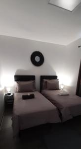 1 dormitorio con 2 camas y espejo en la pared en PAMATAI COSY LODGE en Faaa