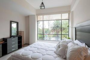 1 dormitorio con cama grande y ventana grande en Central and cozy CDMX 1BR en Ciudad de México