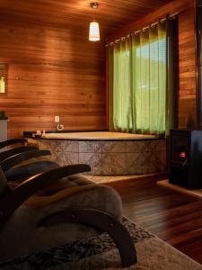 una sala de estar con paredes de madera y una ventana verde. en Pousada Lago da Colina, en Urubici