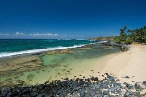 a beach with rocks and the ocean on a clear day at North Shore of Maui - 2bd-2bath in Paia