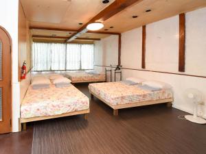 a room with three beds and a window at 国際通り迄徒歩５分【Simple Stay Makishi】 in Naha