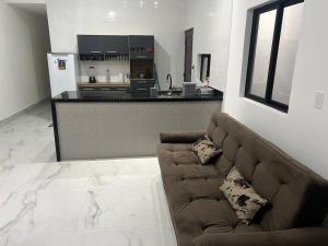 Carapibus casa de praia 02 في كوندي: غرفة معيشة مع أريكة ومطبخ