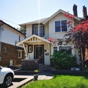 a white car parked in front of a house at A bright and tidy room in midtown near subway in Toronto
