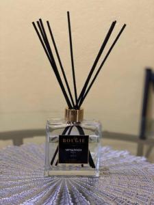 a bottle of perfume with sticks in it on a bed at Hidden Zen 108 with rental vehicle access in Castries