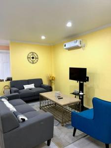 sala de estar con sofá, mesa y TV en Hidden Zen 108 with rental vehicle access, en Castries