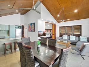 cocina y sala de estar con mesa de madera y sillas en Pure Magnetic Villa 9 en Nelly Bay