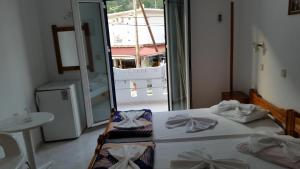 a bedroom with two beds and a large window at Tarra in Agia Roumeli