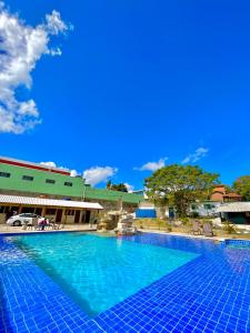 una gran piscina con un cielo azul en el fondo en Pousada Serra de São Thomé, en São Thomé das Letras