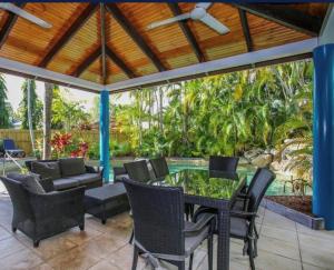 an outdoor dining room with a table and chairs at Trinity Beach Sea Breeze 3 Bedroom Apartment in Trinity Beach