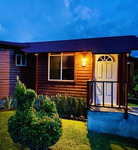 Casa de madera con porche y ventana en Villarreal Lodge Hotel Ecológico en Totolapan