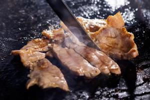 a close up of meat being grilled on a grill at Hotel Taikan in Morioka