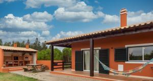ein Haus mit einer Terrasse und einem Tisch in der Unterkunft A casa das minhas netas in Caldas da Rainha