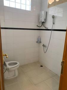 ein Bad mit WC und ein Telefon an der Wand in der Unterkunft Villa Tepi Bukit 