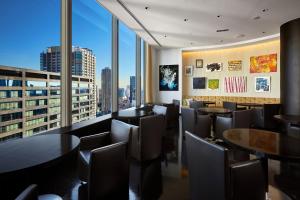 a restaurant with tables and chairs and a large window at Park Hotel Tokyo in Tokyo
