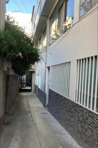 an empty alleyway next to a white building at Departamentos en centro histórico 1 in Ayacucho