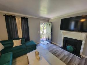 a living room with a green couch and a fireplace at Chickasaw Landing in Chickasaw