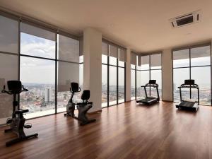 a gym with exercise equipment in a large room with windows at Urban Vista @ The Quartz Residence: City Center Retreat with InfinityPool in Melaka