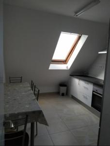 a kitchen with a table and a skylight in a room at El pisin de Claudia in Colombres