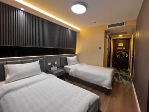 een hotelkamer met 2 bedden en een badkamer bij Hennessy Hotel in Hong Kong