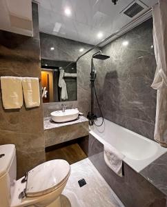 La salle de bains est pourvue de toilettes, d'un lavabo et d'une baignoire. dans l'établissement Hennessy Hotel, à Hong Kong