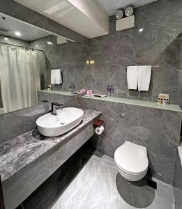 a bathroom with a sink and a toilet at Hennessy Hotel in Hong Kong