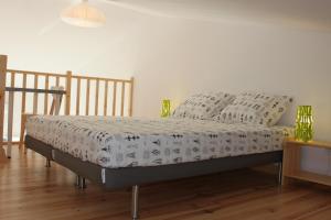 un letto in una camera da letto con pavimento in legno di Les Hirondelles a La Garde