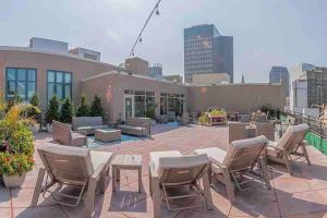 eine Terrasse mit Stühlen und Tischen sowie ein Gebäude in der Unterkunft Beautiful Condo/Rooftop Patio With Free Parking in Cleveland