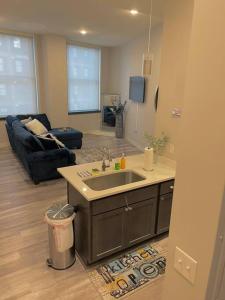 a kitchen with a sink and a living room at Beautiful Condo/Rooftop Patio With Free Parking in Cleveland