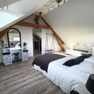 una camera da letto con un grande letto in mansarda di L'écurie d'antan a Hautot-Saint-Sulpice