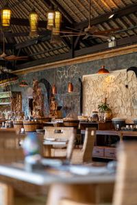 restauracja ze stołami i krzesłami w pokoju w obiekcie Jimbaran Puri, A Belmond Hotel, Bali w mieście Jimbaran