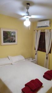 una camera da letto con un letto bianco e asciugamani rossi di Casa Vainilla a La Rioja