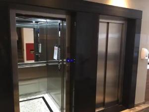 an elevator in a building with a glass door at Apto climatizado -garagem in Florianópolis
