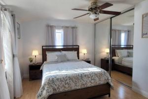 a bedroom with a bed with a ceiling fan and a mirror at Luxstay in Huntington Beach in Huntington Beach