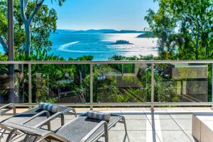 Blue Water Views 16 - 3 Bedroom Penthouse with Ocean Views في جزيرة هاميلتون: شرفة مع كراسي وإطلالة على المحيط