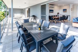 comedor y sala de estar con mesa y sillas en Blue Water Views 16 - 3 Bedroom Penthouse with Ocean Views, en Hamilton Island