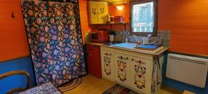 a small kitchen with orange walls and a counter top at roulotte Tipergwendiou in Plougonvelin