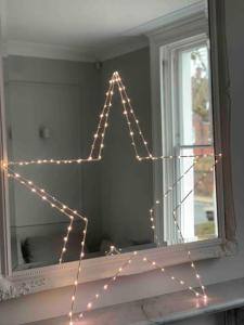 a star decoration in front of a mirror at Stylish Georgian townhouse on Richmond Hill in Richmond