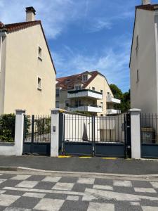 a gate in front of a house with a building at COSY TORCY entre Paris et Disney in Torcy