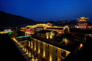 a view of a city at night with buildings at Phoenix Hall House Hotel in Fenghuang