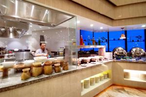 a man in a kitchen preparing food in a kitchen at Yume Dream Genting Highlands in Genting Highlands