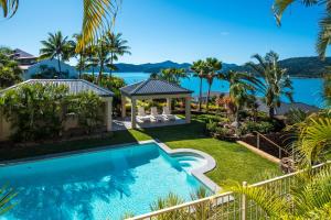 a view of the pool and the ocean from the house at La Bella Waters 5 Oceanview Private Garden BBQ Buggy in Hamilton Island