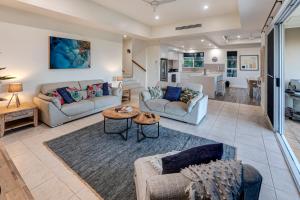 a living room with two couches and a table at La Bella Waters 5 Oceanview Private Garden BBQ Buggy in Hamilton Island