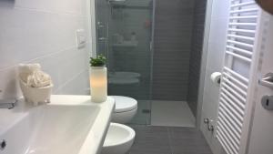 een badkamer met een toilet en een glazen douche bij Innsud in Nardò