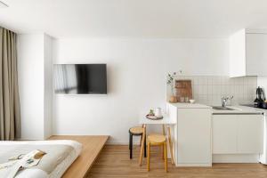 a bedroom with a bed and a table and a kitchen at Urbanstay Boutique Ikseon in Seoul