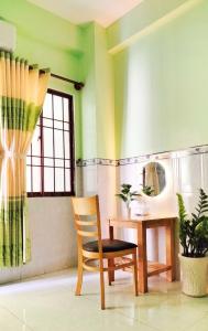 Thai Quang Hotel في فنغ تاو: كرسي في غرفة مع طاولة ومرآة
