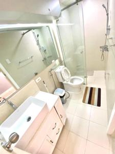 a bathroom with a sink and a toilet and a mirror at Amirah’s Place Azure North in San Fernando