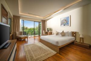 a bedroom with a bed and a television in a room at Luxury Beach Resort Da Nang in Da Nang