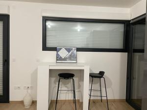 a room with two bar stools and a window at Parking gratuit grande terrasse Proche Centre Ville in Ajaccio +8 photos