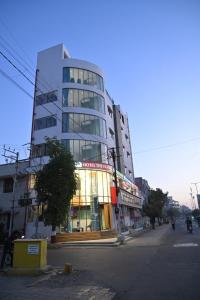 un edificio alto in una strada di città con di Hotel The Faam a Rajkot
